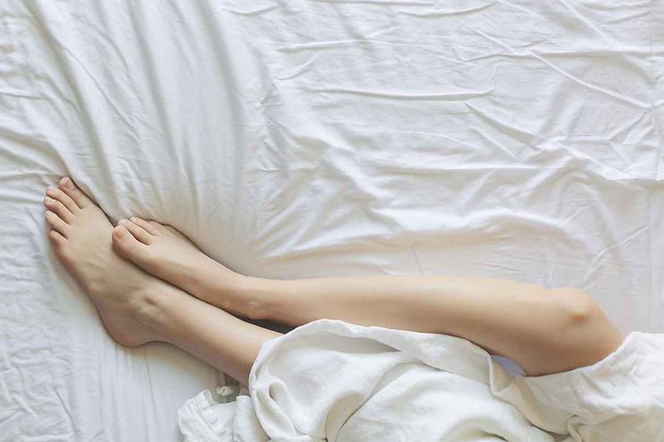 Jambes de femme sur un lit