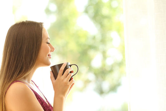 Femme qui boit une tisane de plantes détoxifiantes