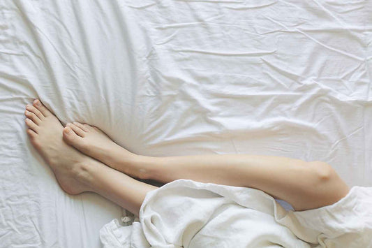 Jambes de femme sur un lit