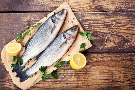 Loup de mer entier sur une planche en bois