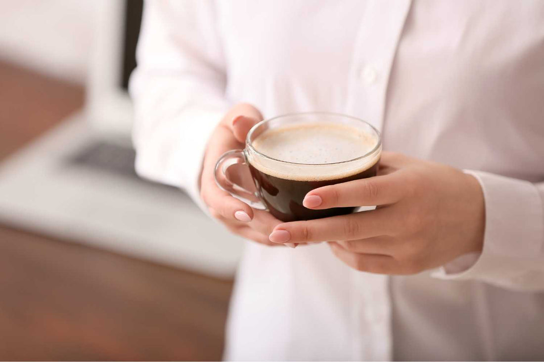 femme tenant une tasse de café dans ses mains