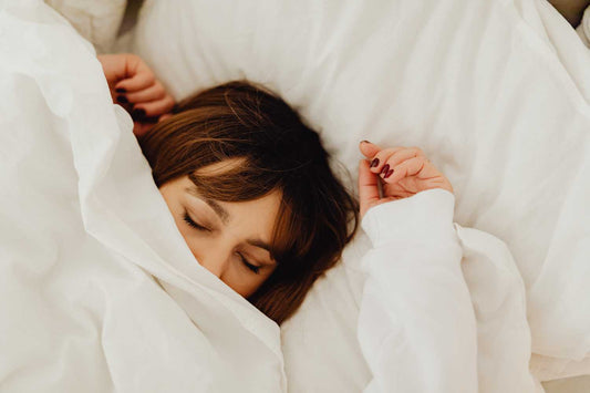 Femme endormie sous sa couette de lit