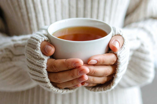 Mains de femme tenant une tasse de tisane pour ménopause