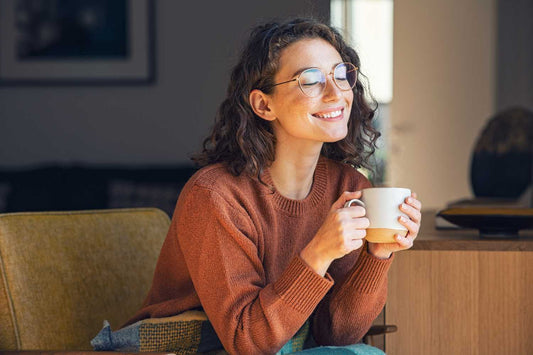 Femme heureuse qui tient une tasse de tisane