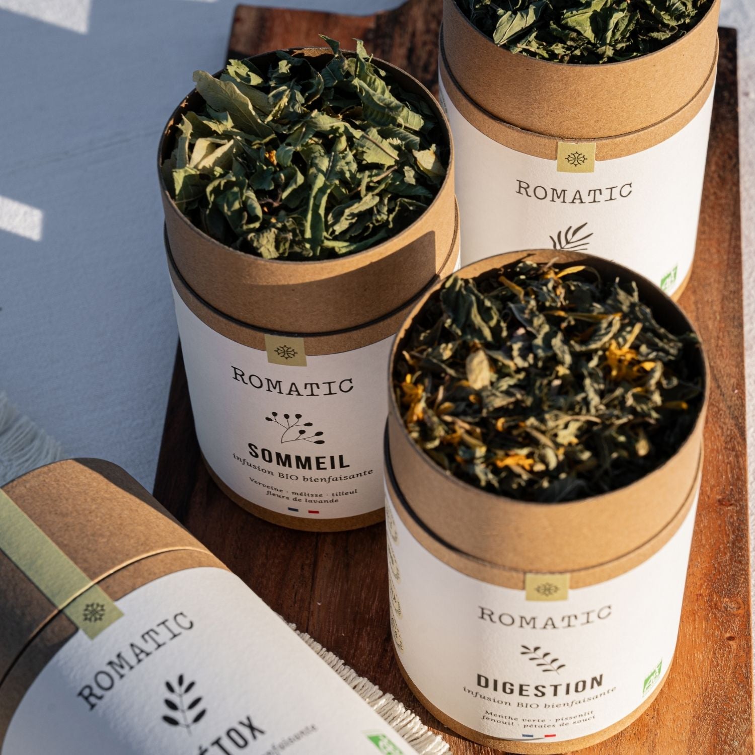Rituel Essentiel – 4 infusions bio (Digestion, Vitalité, Sommeil, Détox) – boîtes ouvertes avec plantes visibles